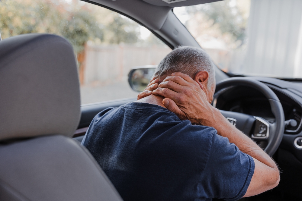 Middle-aged man experiencing discomfort in his neck.